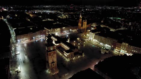 Establishing-bird-eye-view-at-night-of-Krakow-medieval-town-square,-dating-to-the-13th-century,-surrounded-by-palaces-and-churches