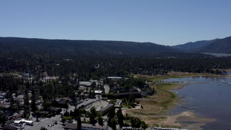 una toma aérea de drones del lago big bear volando hacia las montañas, condado de san bernardino, california