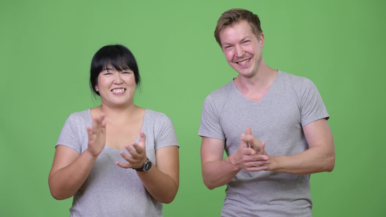 행복한 다민족 커플이 함께 손을 치고 있습니다.