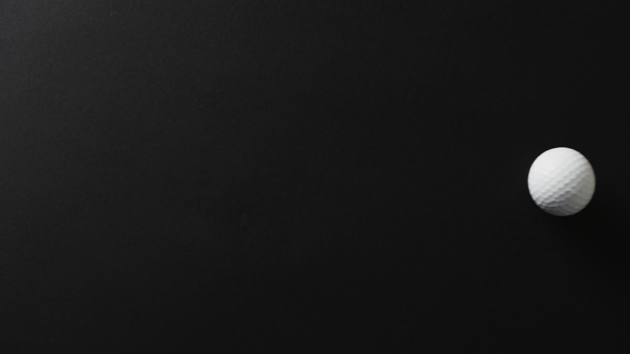 검은 바탕에 있는 골프 공의 클로즈업, 복사 공간, 슬로우 모션