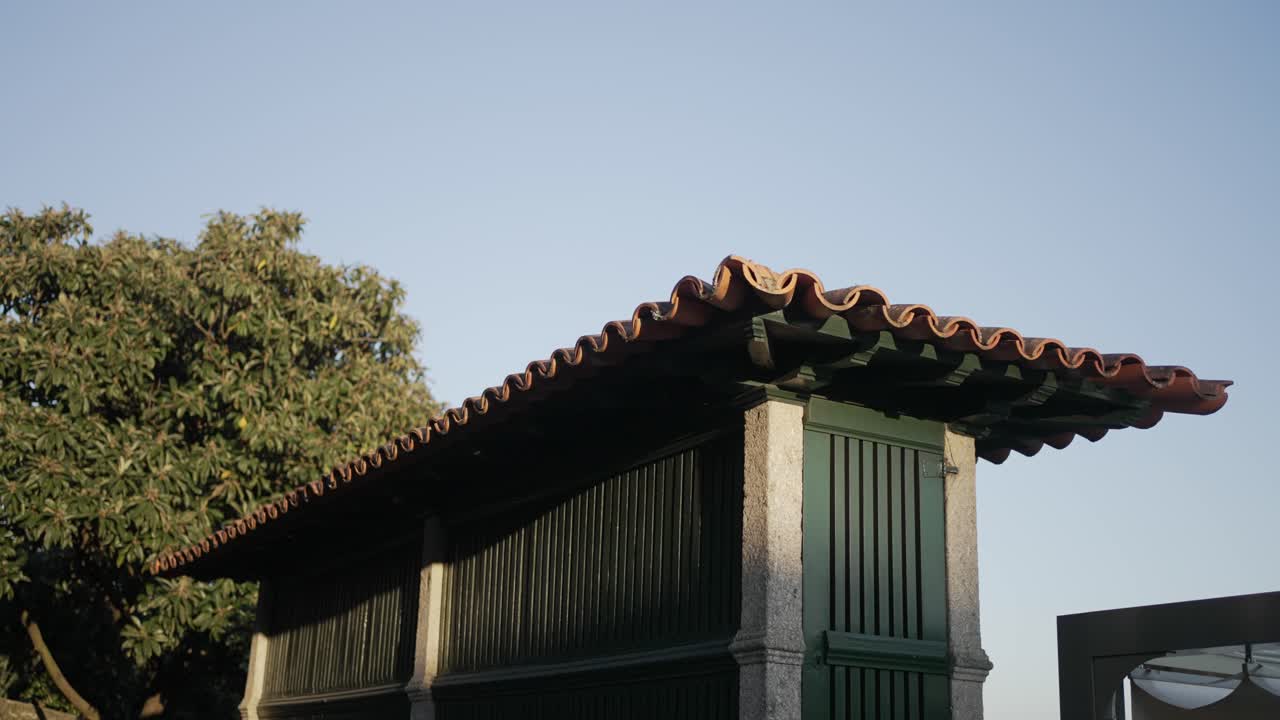 Old stone granary with wooden panels under evening sky and soft warm light