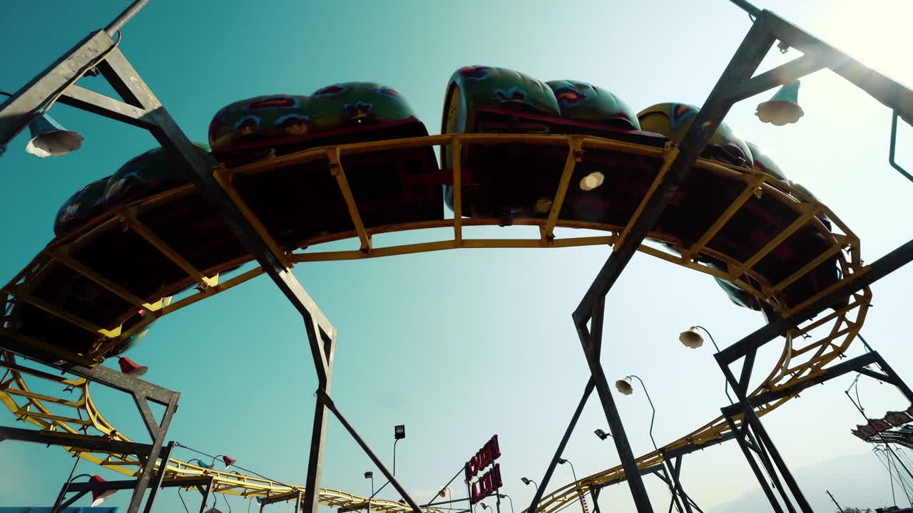 테마 파크 에 있는 사람 들 이 가득 찬 열차 와 함께 롤러코스터