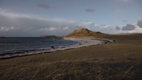 time-lapse clouds over the ocean, green meadow, shore and mountains at the background, highlands, scotland, static shot