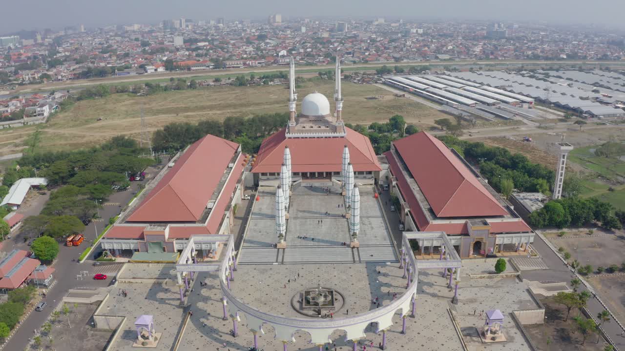 Aerial view of a large mosque complex with modern architecture, surrounded by greenery and urban landscape called MAJT Semarang