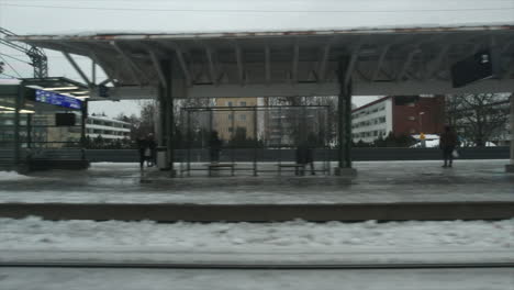 winter city train pulls into snowy station platform on cold grey day