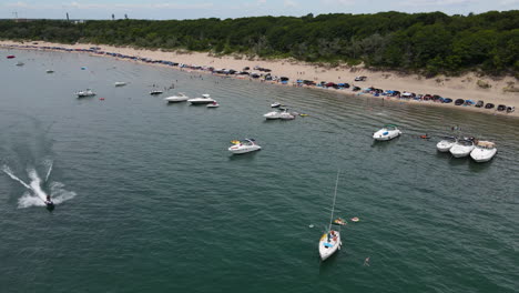 motorboats and cars lined up in the shore of nickel beach in port colborne- annual canal days in ontario, canada