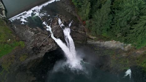 overhead aerial of snoqualmie falls gushing glacial water