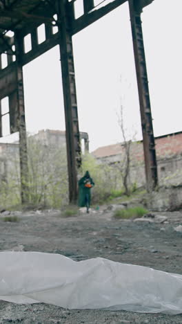 abandoned building with garbage inside. scientist in protective uniform in destroyed building. biological attack. vertical video