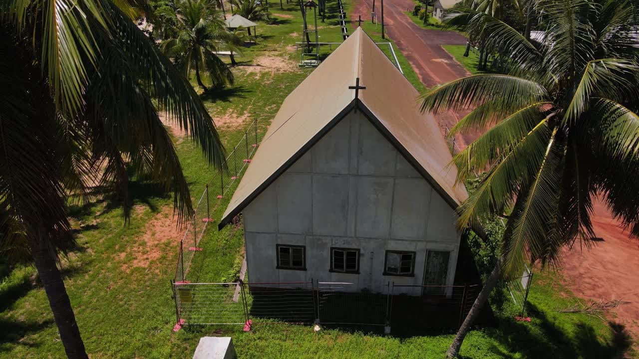 Vertikaler Luftbildclip mit langsamer Abwärtsneigung einer verlassenen Kirche im abgelegenen tropischen Australien