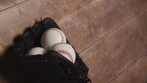 estudio de béisbol de arriba todavía la vida con bolas en receptores guante en el suelo de madera