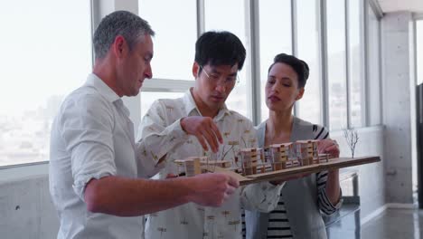 multi-ethnic business people discussing over factory model in modern office 4k