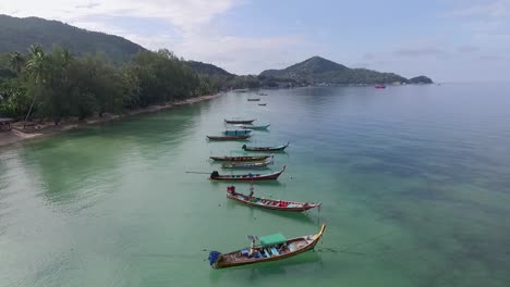 Flying-backward-above-empty-longtail-boats-and-reef-island-background