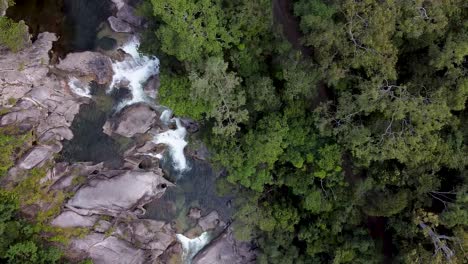 aerial top down view over behana gorge surrounded by trees with water flowing down