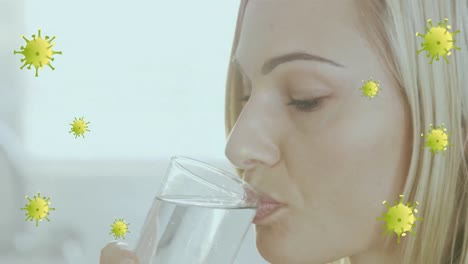 animation of virus cell over sick caucasian woman drinking water