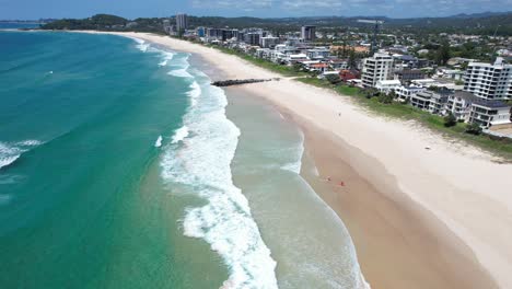 ocean waves splashing sandy shore of palm beach in gold coast, queensland, australia - aerial drone shot