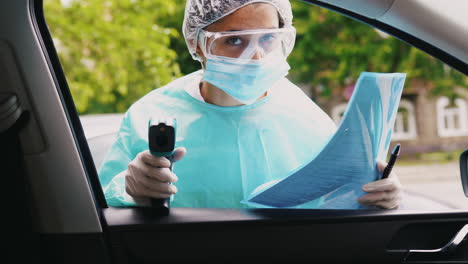 medical professional conducting temperature check on person in a car