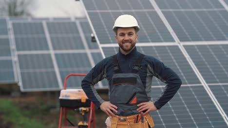 retrato de primer plano de un trabajador masculino en un uniforme con herramientas en el fondo de una planta de energía solar