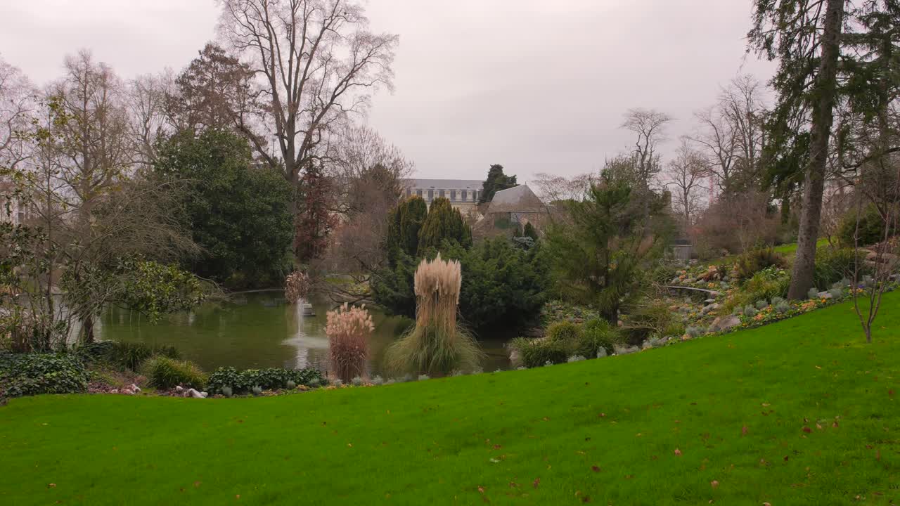 jardin des plantes d'angers parque con césped verde y estanque en angers, francia - amplio