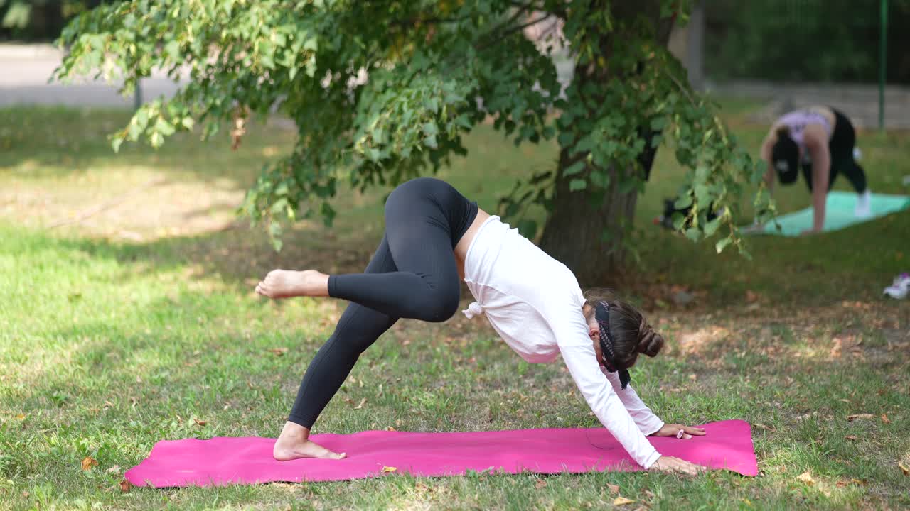 mujer practicando yoga al aire libre en un parque