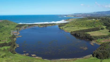 Iconic-stretch-of-sandy-beach-at-The-Farm-Shell-Cove,-Killalea-New-South-Wales,-aerial-pullback