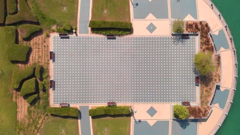 Toma-Aérea-Sobre-Una-Plaza-Moderna-Con-Un-Carril-Bici-Cerca-Del-Agua-En-Abu-Dhabi