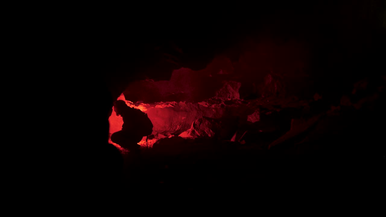 Erkundung einer Höhle bei Nacht mit rotem Licht