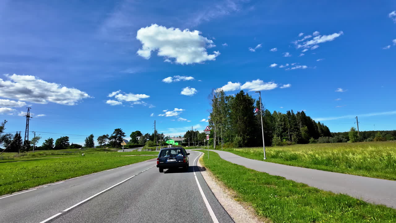 Road trip along serene countryside on a sunny day in Estonia
