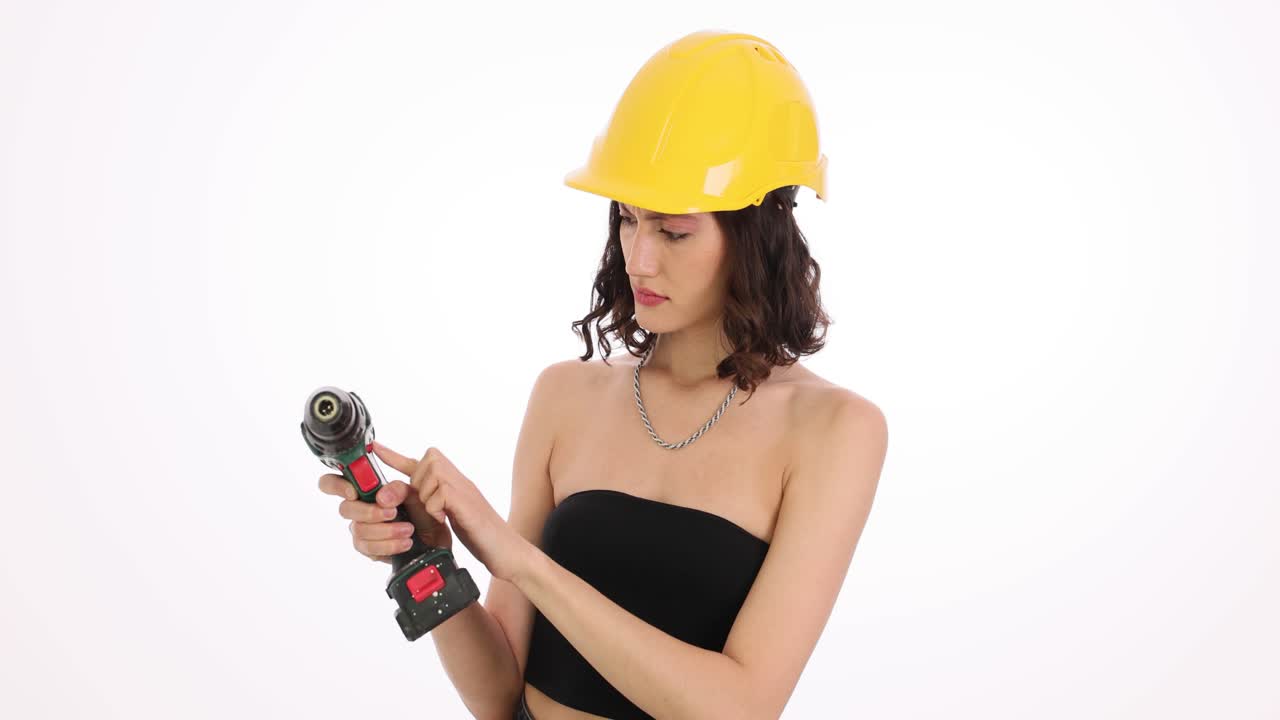 Woman in a hard hat handling a cordless drill