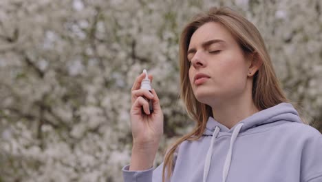 Woman using nasal spray outdoors in spring