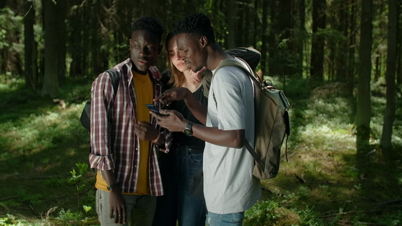 Friends Looking at a Smartphone in the Forest