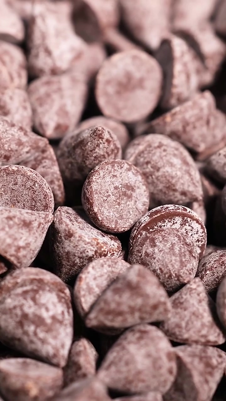 A detailed vertical shot showing a large abundance of brown chocolate baking morsels.