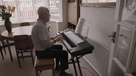 elderly man playing piano at home