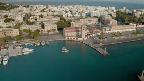 An-aerial-city-view-of-Rhodes-island-in-Greece-containing-clips-of-the-medieval-old-town,-the-old-lighthouse-at-the-port,-old-windmills,-beaches-and-amazing-sunset