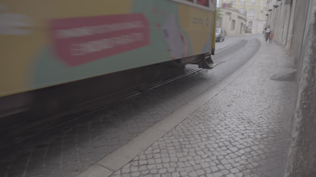 Tranvía turístico amarillo en las pequeñas calles de Lisboa, Portugal LOG