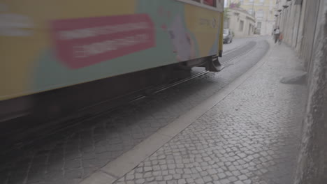 Yellow-tourist-tram-in-the-small-streets-of-Lisboa-Portugal-LOG