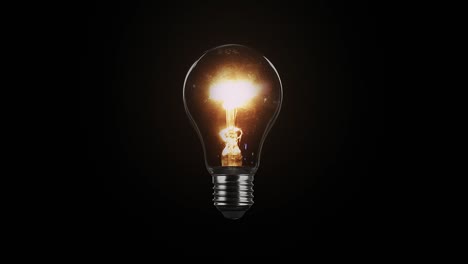 tungsten light bulb isolated on black background. glass and metal base. lights up brightly with a blink and fades out. loop video in 4k resolution