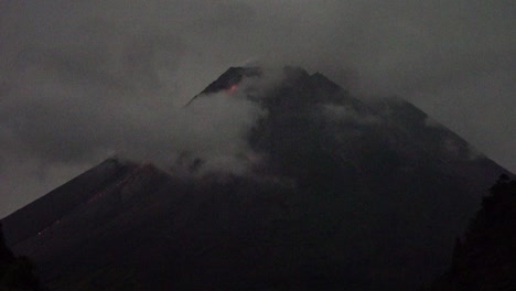 mist enveloped the peak of mount merapi which i erupting, emitting hot mo