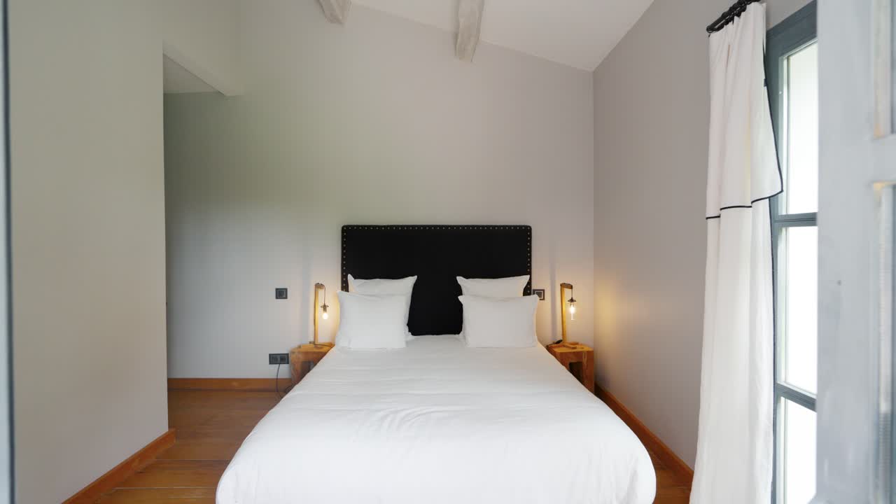 un disparo lento revelando un dormitorio doble minimalista dentro de una villa