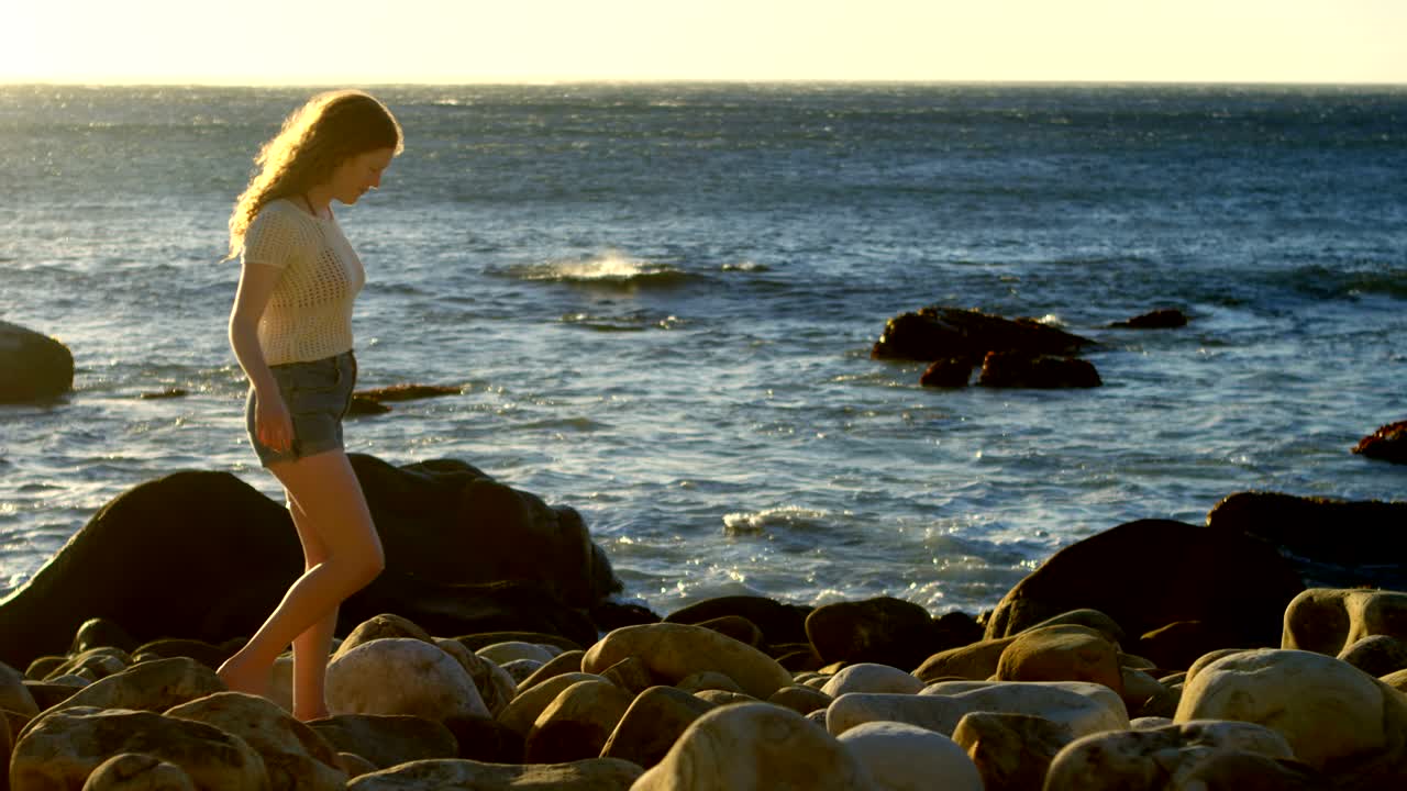 Donna che cammina sulla spiaggia in una giornata di sole 4k
