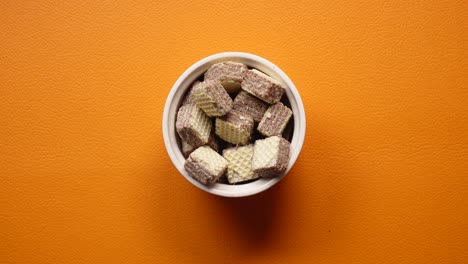 close up of a hand reaching for a chocolate wafer snack