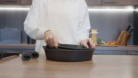 mujer preparando comida con ollas y sartenes en la cocina