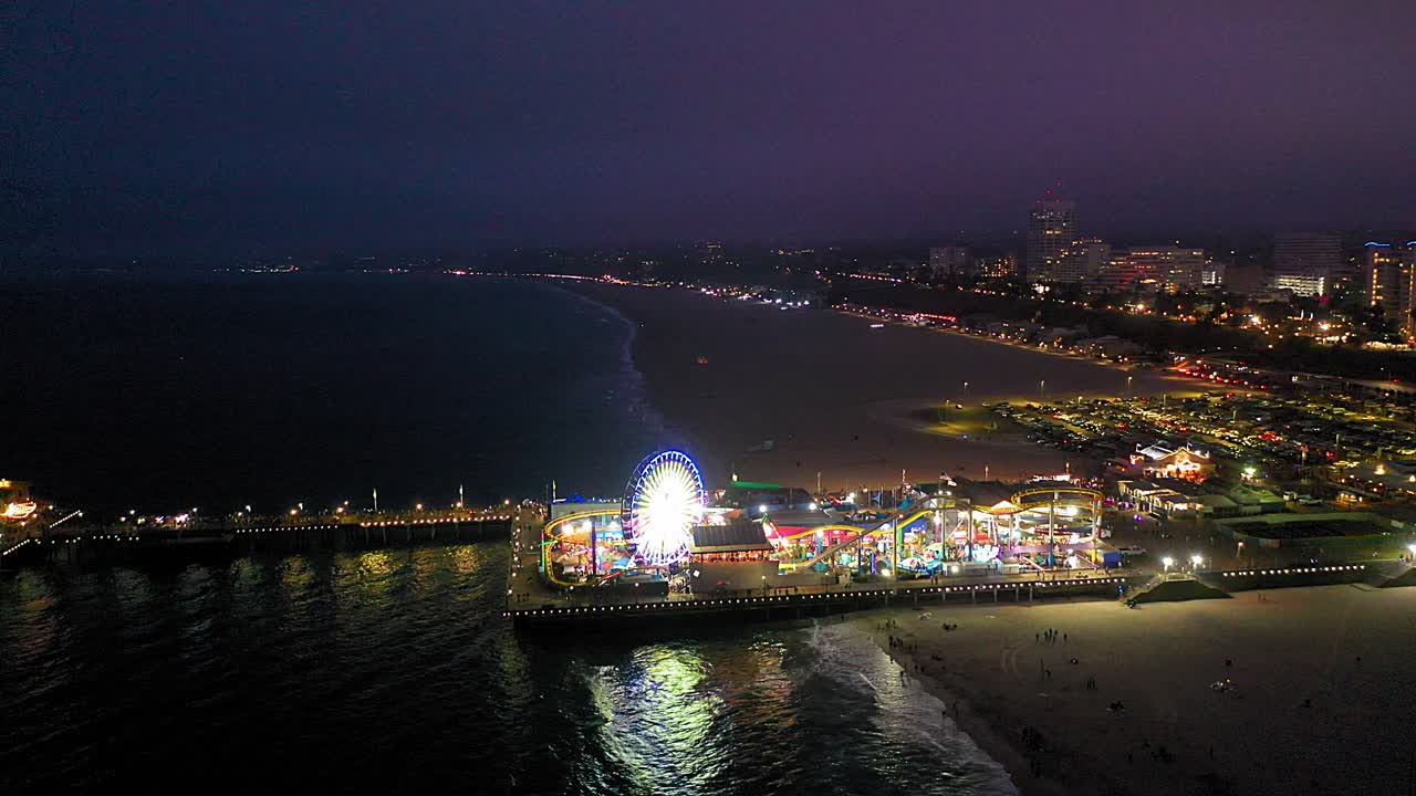 gran toma aérea de drones de la rueda de la fortuna y la montaña rusa en el muelle de santa mónica en el sur de california