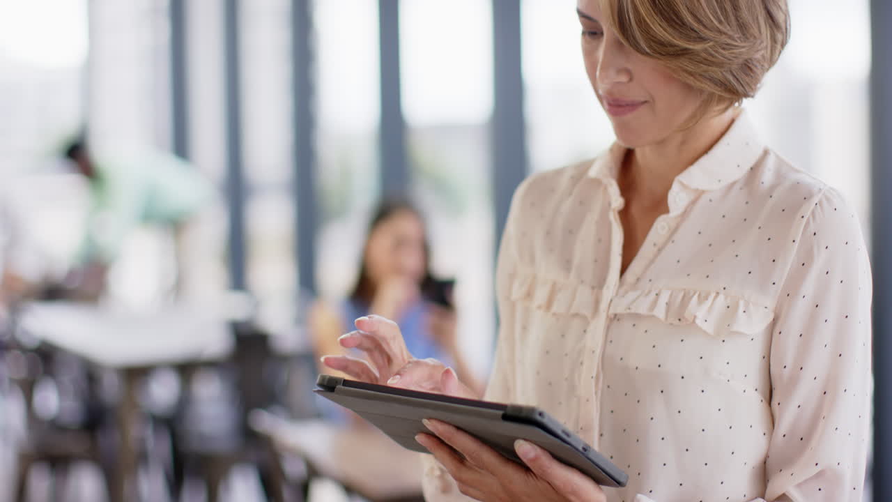 Using tablet, businesswoman working in modern office environment, focusing on task, copy space