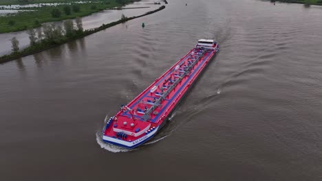 aerial view of a red and blue barge on a river