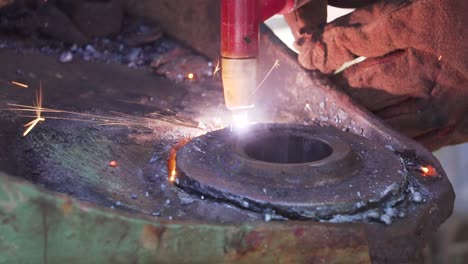 blow torch cutting out a circle piece of metal slowmotion