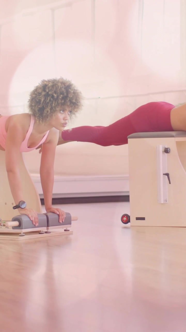 Due donne che si allenano su attrezzatura Pilates con sovrapposizione di animazione bokeh rosa