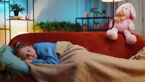 tired teen child girl kid lying down in bed taking a rest at home napping falling asleep on sofa