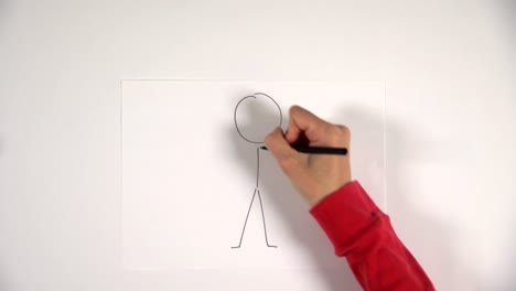 la mano dibuja un boceto de hombre de palo en una hoja blanca, cobra vida.
