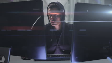 Caucasian hooded hacker man with two computers