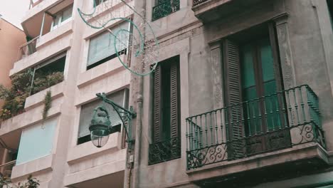 street lantern hanging on the corner of a building in the city center of barcelona